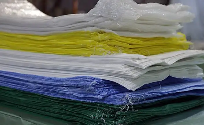 PP woven bags in several colours, folded and bundled
